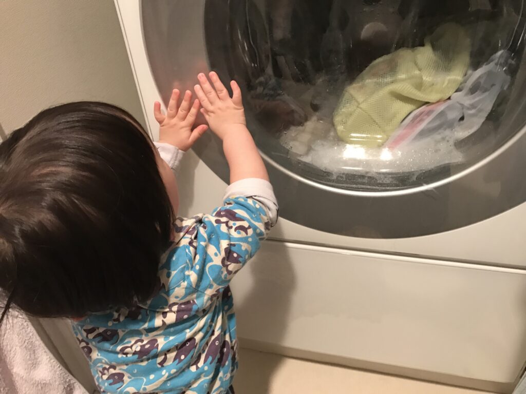 洗濯機を眺める赤ちゃん